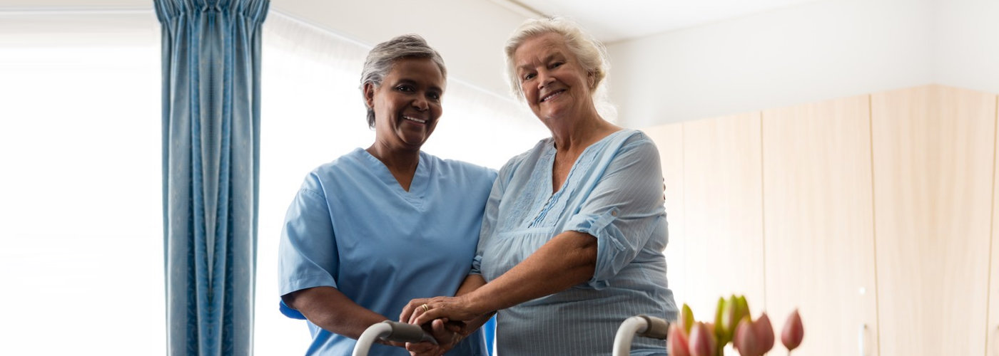 caregiver and a senior woman smiling